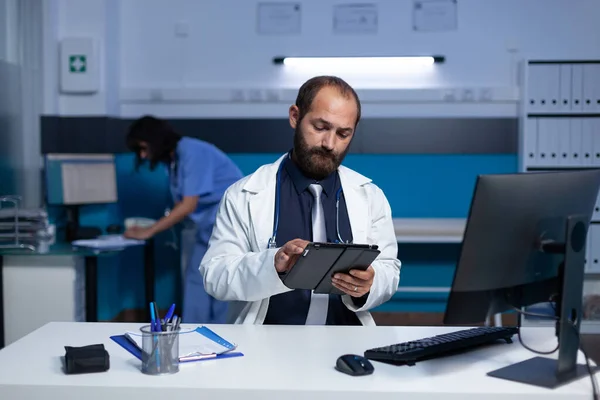 Hombre trabajando como médico con tableta digital y computadora —  Fotos de Stock