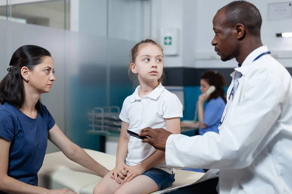 Médico pediatra afroamericano analizando experiencia en enfermedad escribiendo tratamiento de salud —  Fotos de Stock