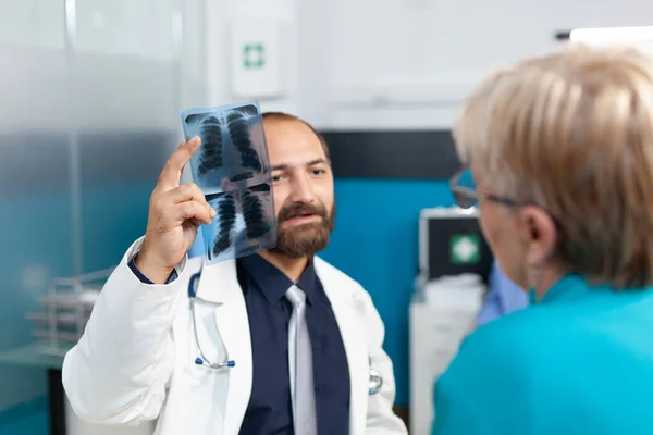 Primer plano del médico que sostiene el escáner de rayos X para explicar los resultados del análisis —  Fotos de Stock