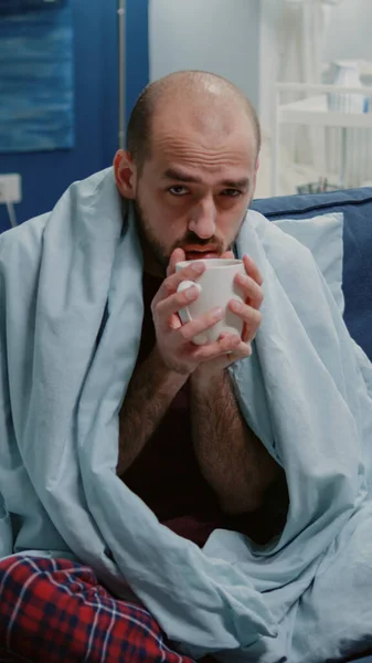 Man with cold shivering and drinking cup of tea — Stock Photo, Image