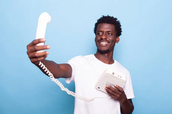 Afro-Amerikaanse man die doet alsof hij selfie neemt op oude vaste telefoon — Stockfoto