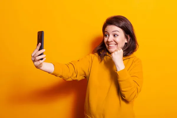 Mujer caucásica mirando el teléfono inteligente y sonriendo — Foto de Stock