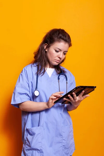 女护士穿著制服与数码平板电脑一起工作 — 图库照片