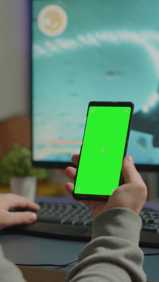 Vídeo vertical: Concentrate gamer holding phone with mock up display — Vídeos de Stock