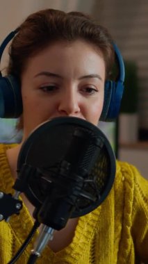 Dikey video: Profesyonel mikrofon kayıt podcast 'ini düzenleyen kadın