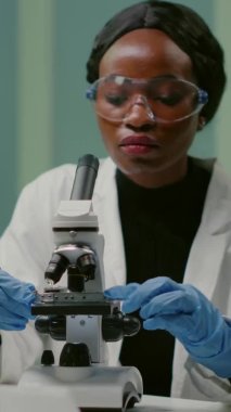 Dikey video: Eczacı kadın portresi mikroskop altına alınıyor