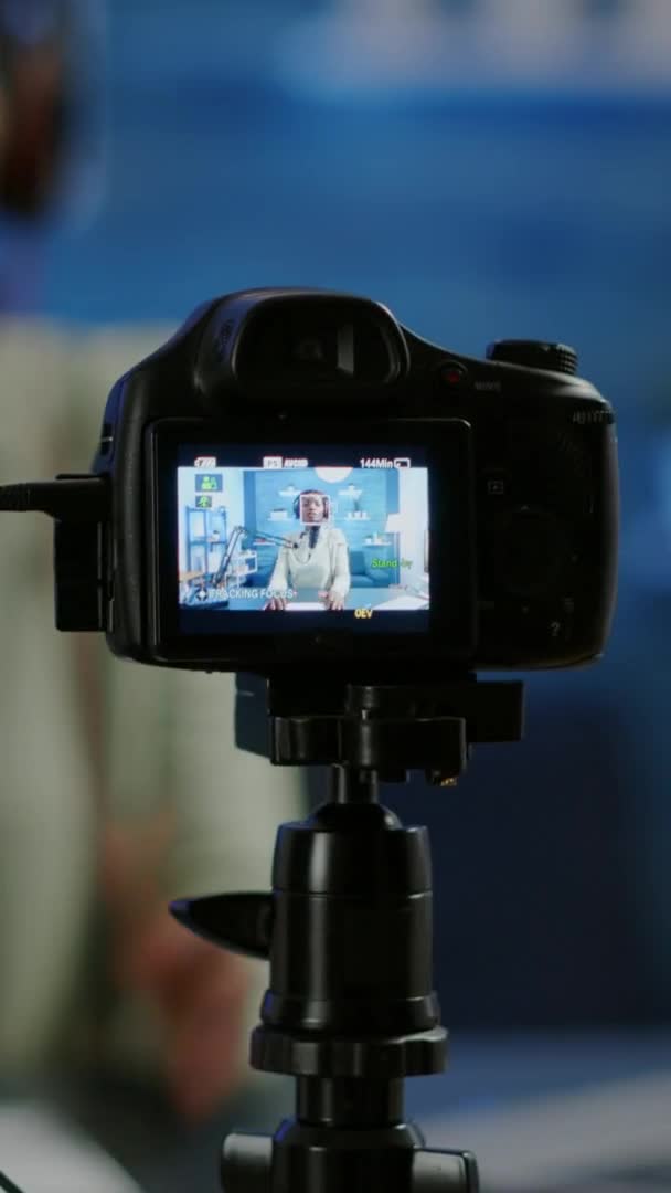Video vertikal: Tutup kamera profesional yang duduk di depan rekaman dslr — Stok Video