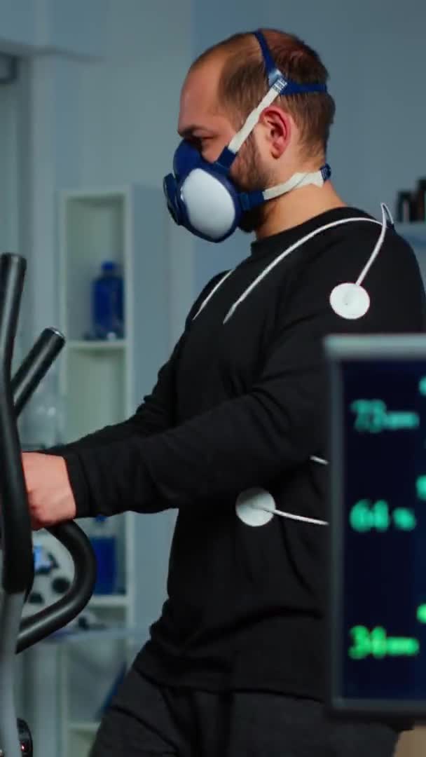 垂直ビデオ:パフォーマンスekg機器で心拍数を測定するパフォーマンススポーツマン — ストック動画