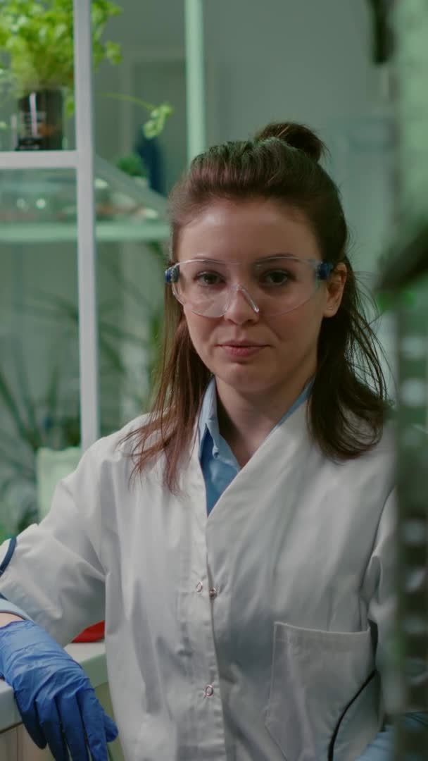 Vertikal video: Porträtt av kemist kvinna i vit rock arbetar i farmaceutiskt laboratorium — Stockvideo