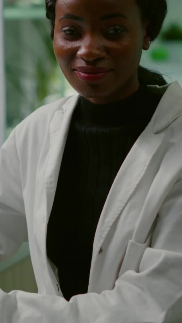 Vídeo vertical: Retrato da pesquisadora bióloga de casaco branco olhando para a câmera — Vídeo de Stock