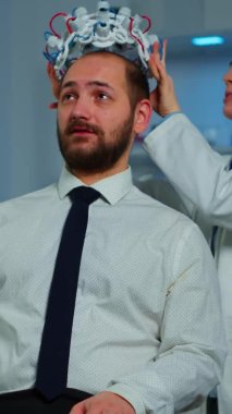 Dikey video: Beyin dalgaları tarama kulaklığı kullanarak beyin analizi yapan nörolog doktor