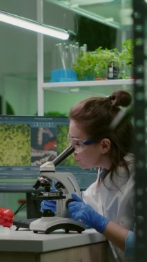 Dikey video: Mikroskop kullanarak kimyasal testi inceleyen biyokimya doktoru