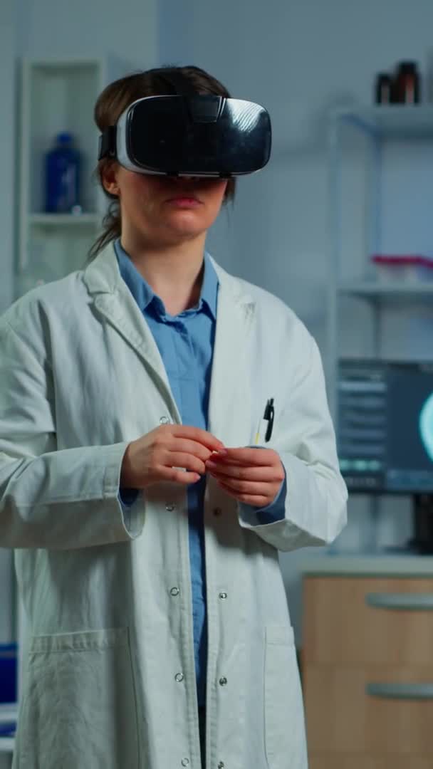 Κάθετη βίντεο: Νευρολογικός επιστήμονας που χρησιμοποιεί ιατρική inovation στο εργαστήριο φορώντας γυαλιά VR — Αρχείο Βίντεο