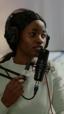 Dikey video: Online programın Afrikalı kadın sunucusu mikrofona konuşuyor
