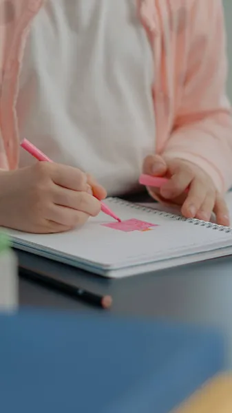 Közelkép a fiatal gyermek segítségével színes ceruzák a notebook — Stock Fotó