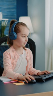 Ders kitabına göre çizen ve bilgisayar kullanan küçük çocuk