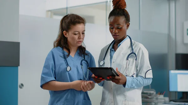 Gruppo di medici e infermieri che analizzano la diagnosi su tablet — Foto Stock