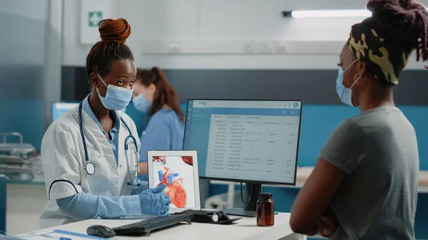 Médecin pointant vers la tablette avec organe cardiaque à l'écran — Photo