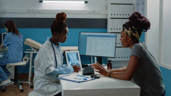 Patient afro-américain et médecin regardant la radiographie — Photo