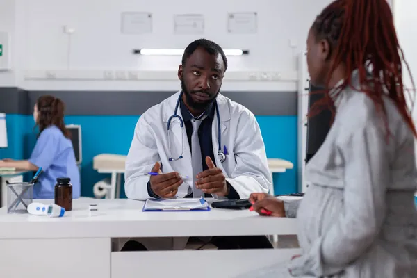 Médico afro-americano e paciente com gravidez conversando — Fotografia de Stock