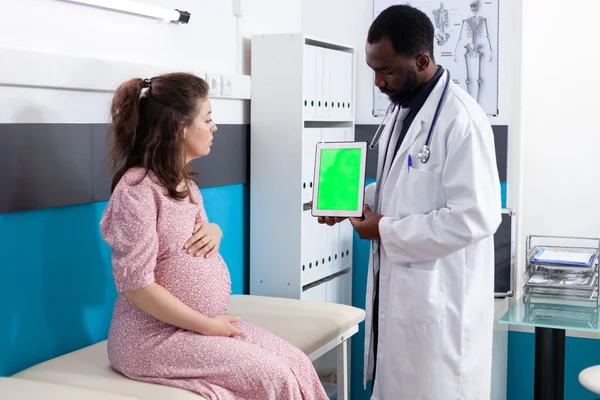 Tablette dikey yeşil ekrana bakan hamile bir kadın. — Stok fotoğraf