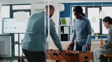 Erkek ve kadın langırt masasında futbol oynuyorlar.