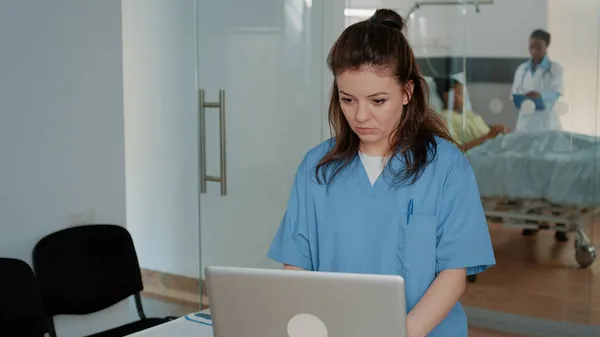 Assistente médico trabalhando com computador para ajudar o médico — Fotografia de Stock
