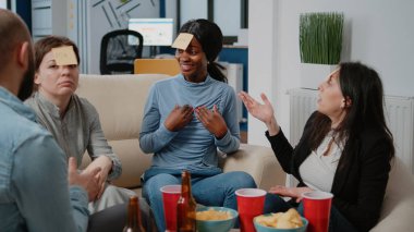 Afro-Amerikalı kadın yapışkan notlarla oyunu tahmin etmeye çalışıyor.