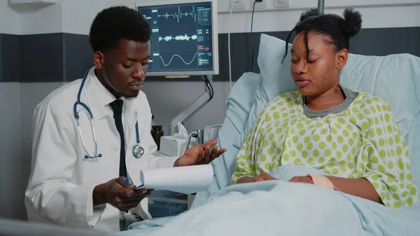 Afrikansk amerikansk läkare konsultera patient med IV droppåse — Stockfoto