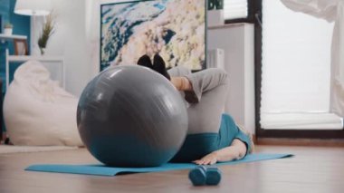 Yaşlanan kişi kaslarını çalıştırmak için fitness tonlama topunu kullanır