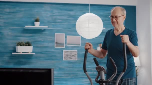 Ανώτερος που κάνει σωματική άσκηση σε σταθερό ποδήλατο — Αρχείο Βίντεο