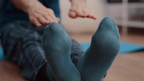 Närbild av senior man gör muskler stretcha på golvet — Stockvideo