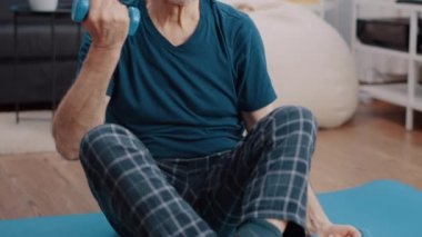 Emeklilik eğitimini yoga minderinin üzerinde dambıllarla kapatın.
