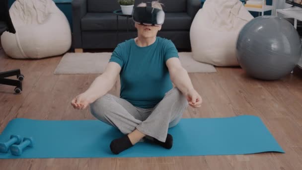 У віці жінка використовує vr окуляри для медитації на йога килимок — стокове відео