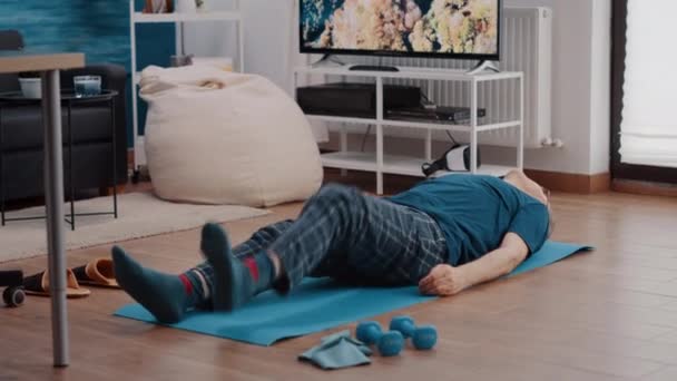 Aîné posé sur tapis de yoga et muscles d'entraînement — Video