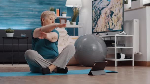 Anciano haciendo ejercicio físico y viendo lección en línea — Vídeo de stock