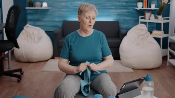 Stará žena sledování online cvičení program na tabletu — Stock video