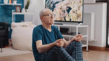 Nilüfer pozisyonunda meditasyon yapan emeklinin el kamerası görüntüsü.