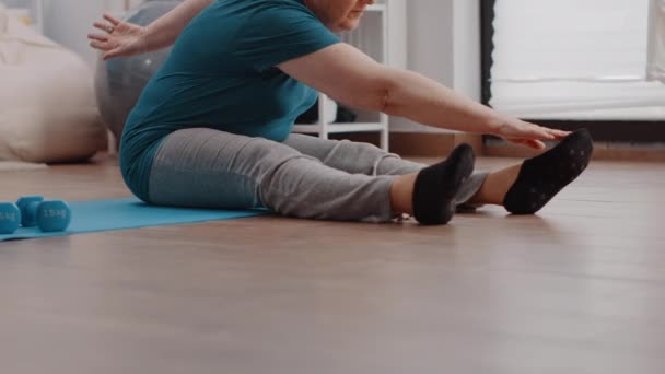 Close-up van gepensioneerde doen lichamelijke oefening om spieren te rekken — Stockvideo