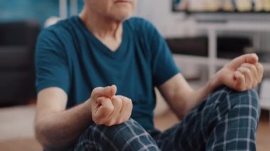 Yaşlı adamın meditasyon yaparken ve nefes alırken çekilmiş el kamerası görüntüleri.