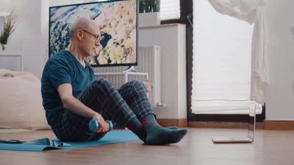 Uomo anziano che si allena con i manubri sul tappeto yoga — Video Stock