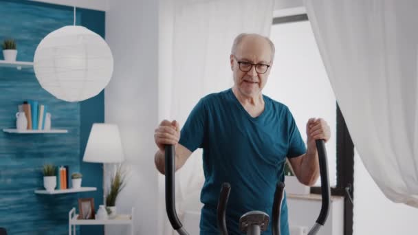 Старший дорослий робить фізичні кардіо вправи на фітнес-велосипеді — стокове відео