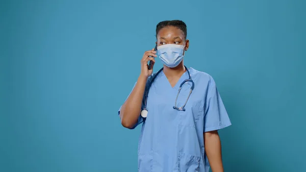African american assistant with face mask talking on phone call — Stock Photo, Image