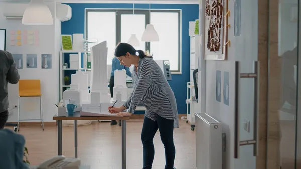 Architect holding building model to design blueprints plans and structure for urban project — Stock Photo, Image