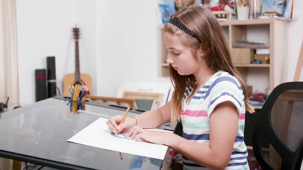 Молодий художник тримає графічний олівець, малюючи барвисті картини для художньої школи — стокове фото