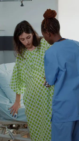 Африканская американская медсестра помогает беременной женщине — стоковое фото