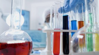 Tıbbi şeffaf test tüpleri üzerinde çalışan ekipmanlı bilim adamı uzman doktor.