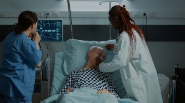 Çok ırklı hemşire ve doktor hasta hastaya yardım ediyor