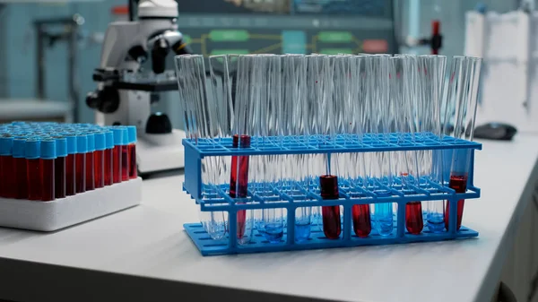 Gros plan des éprouvettes de laboratoire avec du sang sur le bureau — Photo