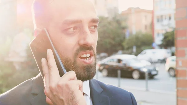 Portret biznesmena stojącego przed budynkiem biurowym rozmawiającego przez telefon — Zdjęcie stockowe